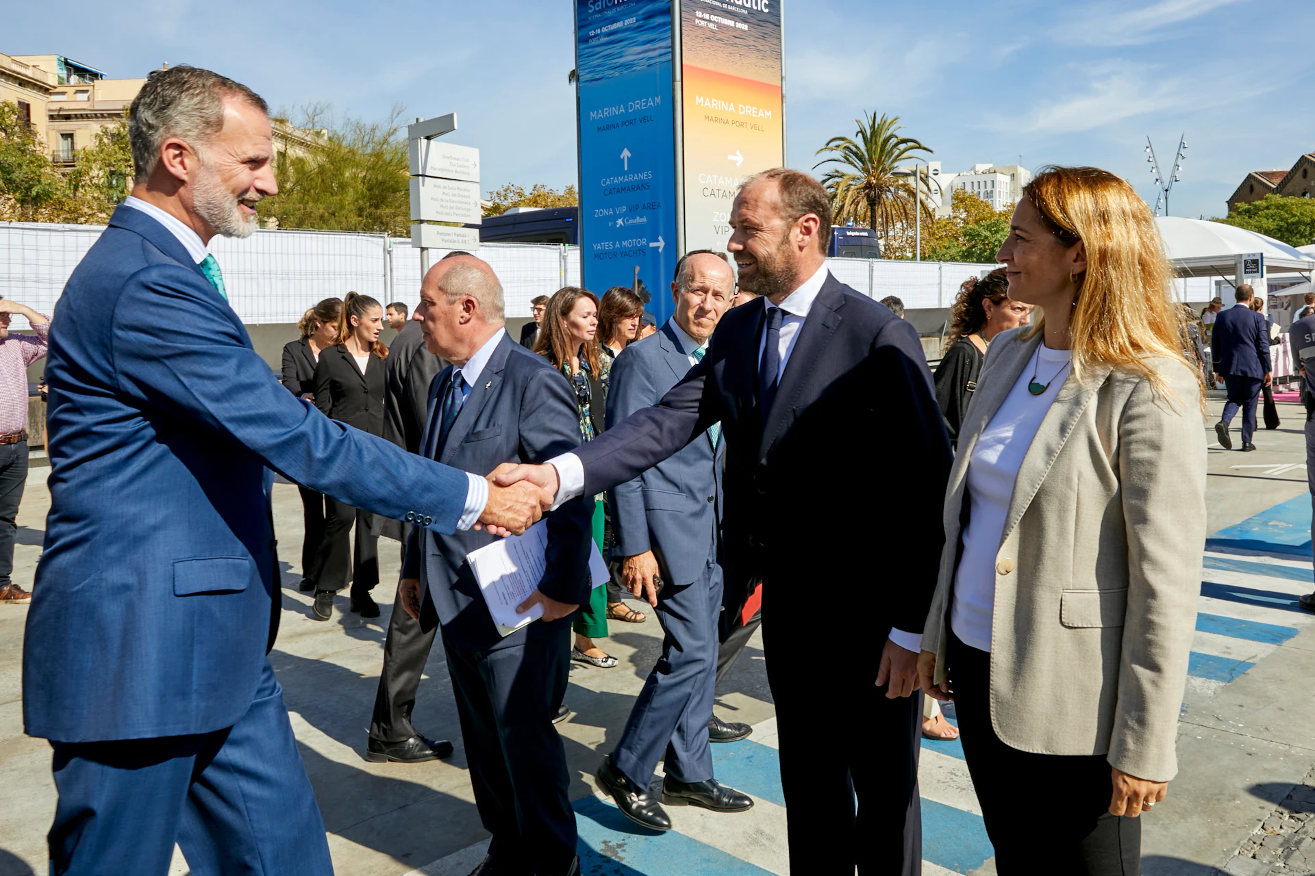 Hombre con traje azul dando la mano a un funcionario en un evento de Marina Port Vell en Barcelona.