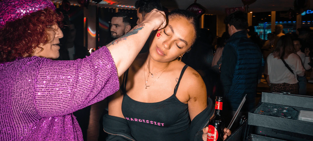 maquilladora profesional aplicando uno de sus diseños en una jóven durante la Love Crew Party