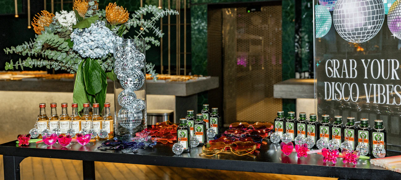 Barra decorada con bebidas y accesorios durante la Crew Disco Night en Marina Port Vell