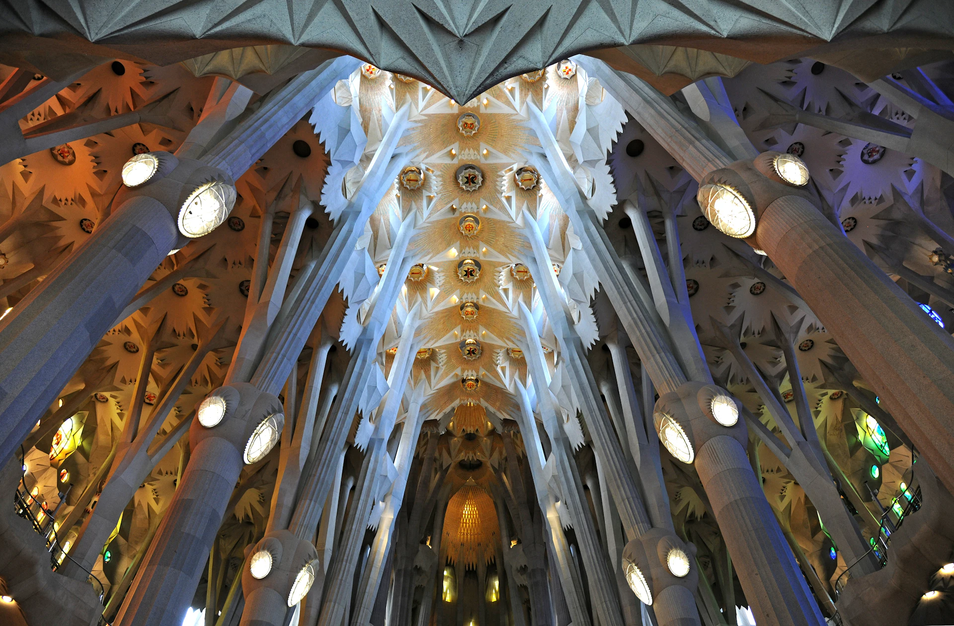 Interior ceiling of Sagrada Familia basilica with vaulted ribs and ornate sculptural details.
