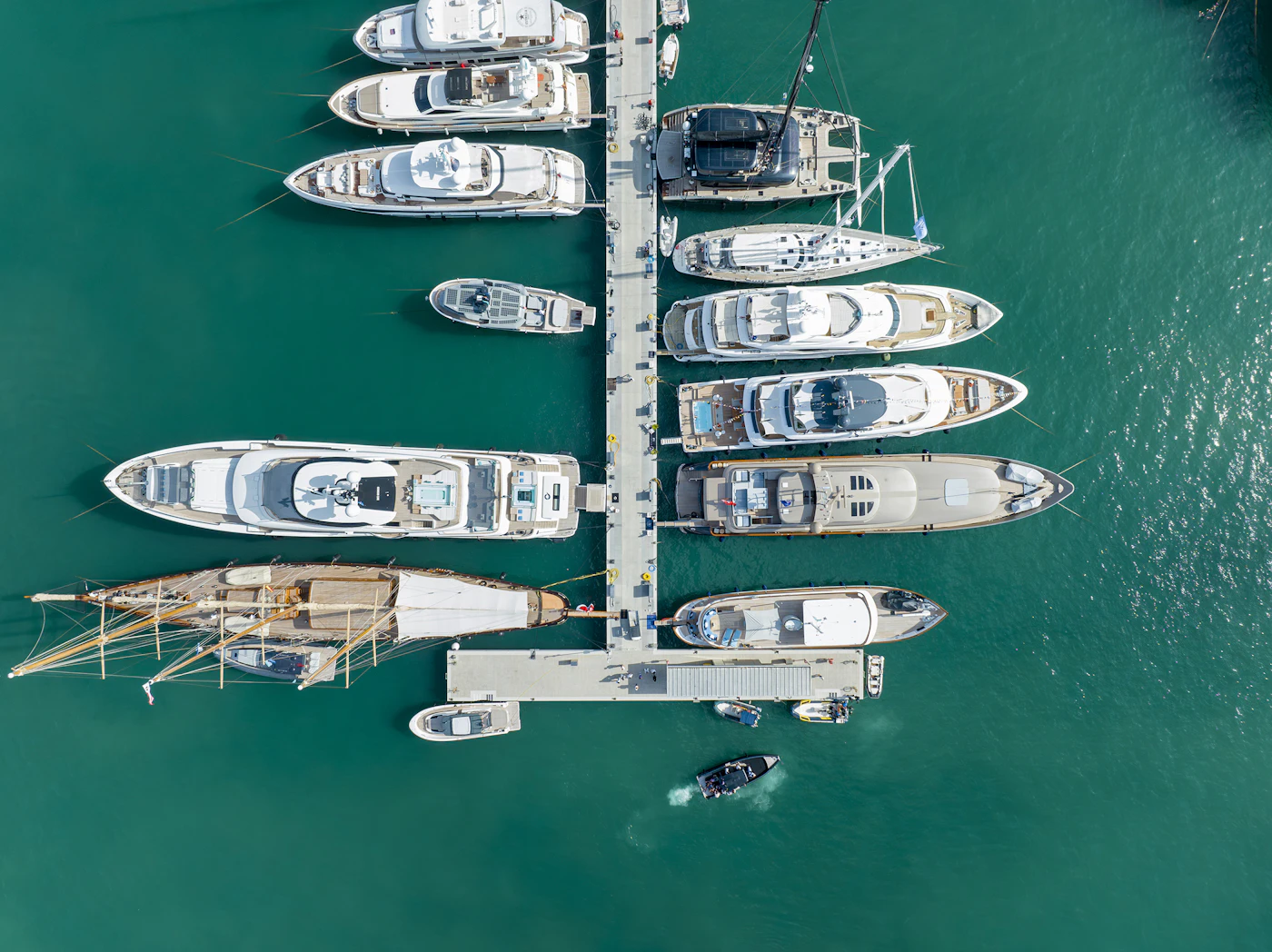 Aerial view of yachts moored along both sides of a marina dock.
