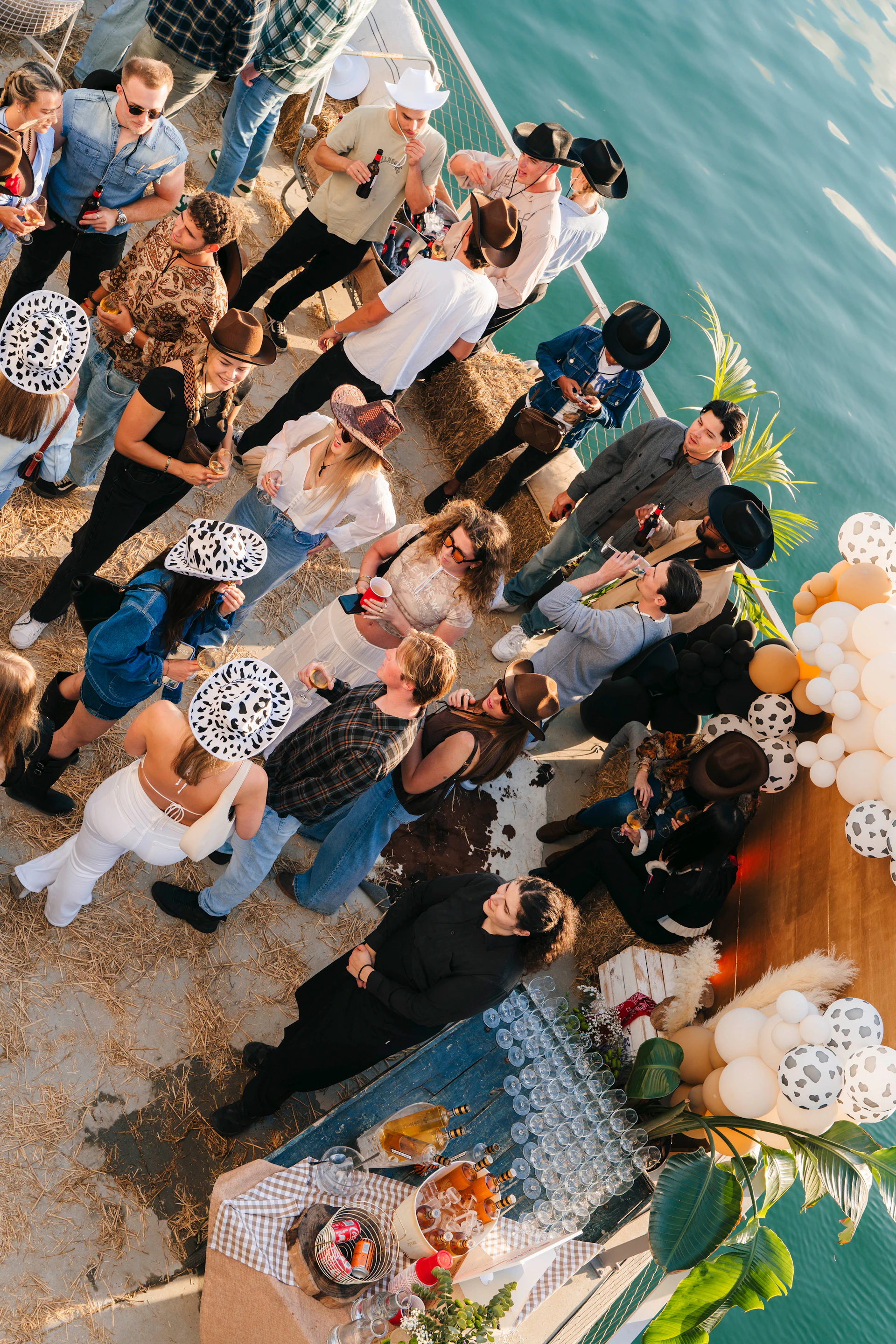 Group of people gathered on a marina dock for a social event with food and drinks.