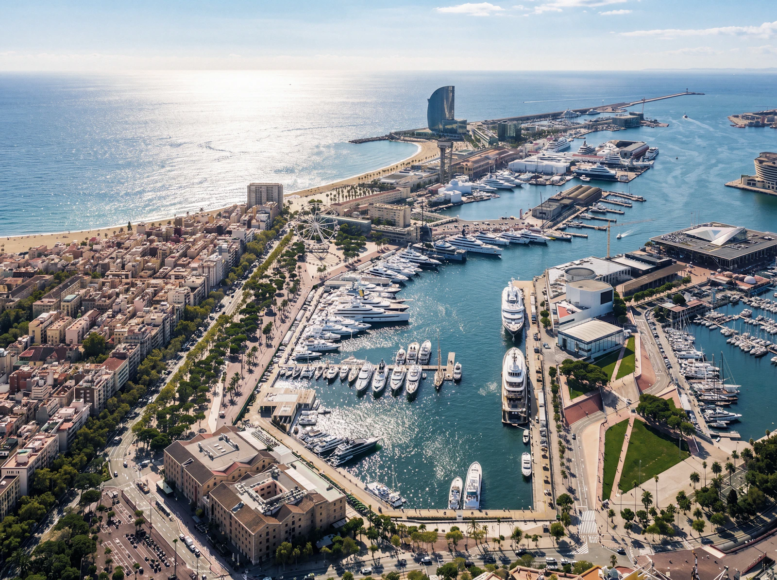 Aerial view of a Barcelona marina full of yachts beside the city and beach.