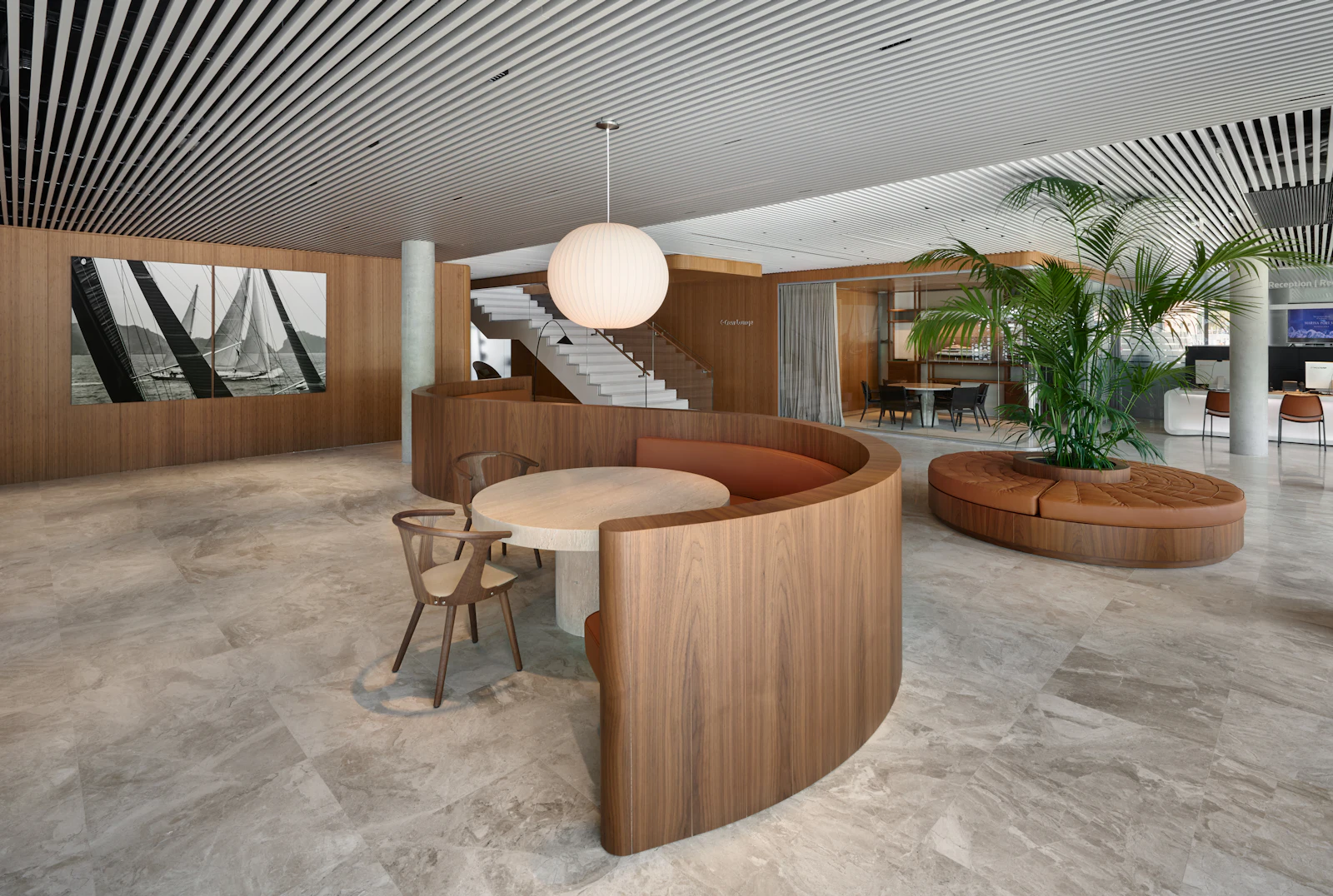 Vestíbulo moderno con asientos curvos de madera, suelo de mármol, fotografía de vela y escalera.