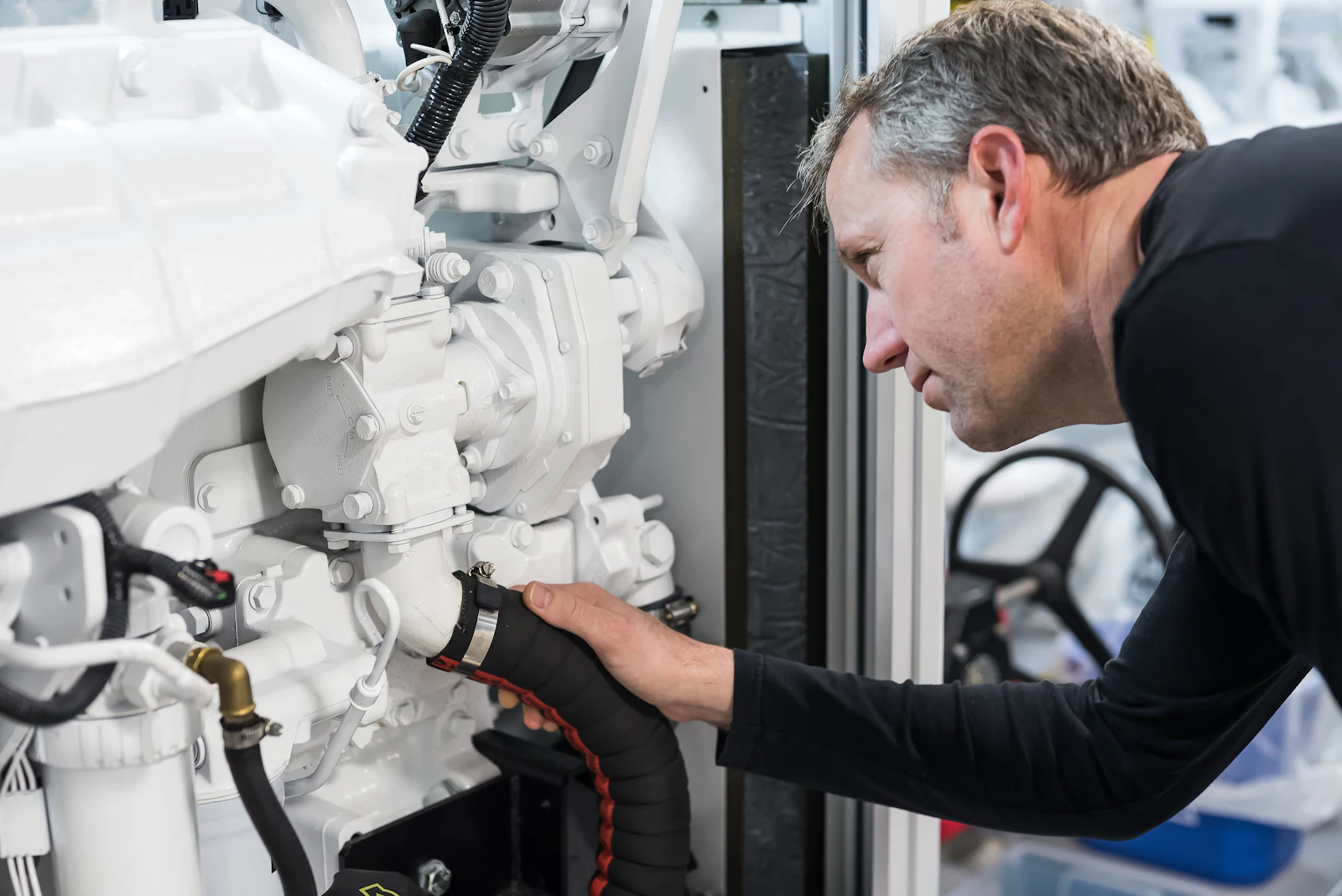 Técnico inspeccionando componentes blancos del motor en un superyate.