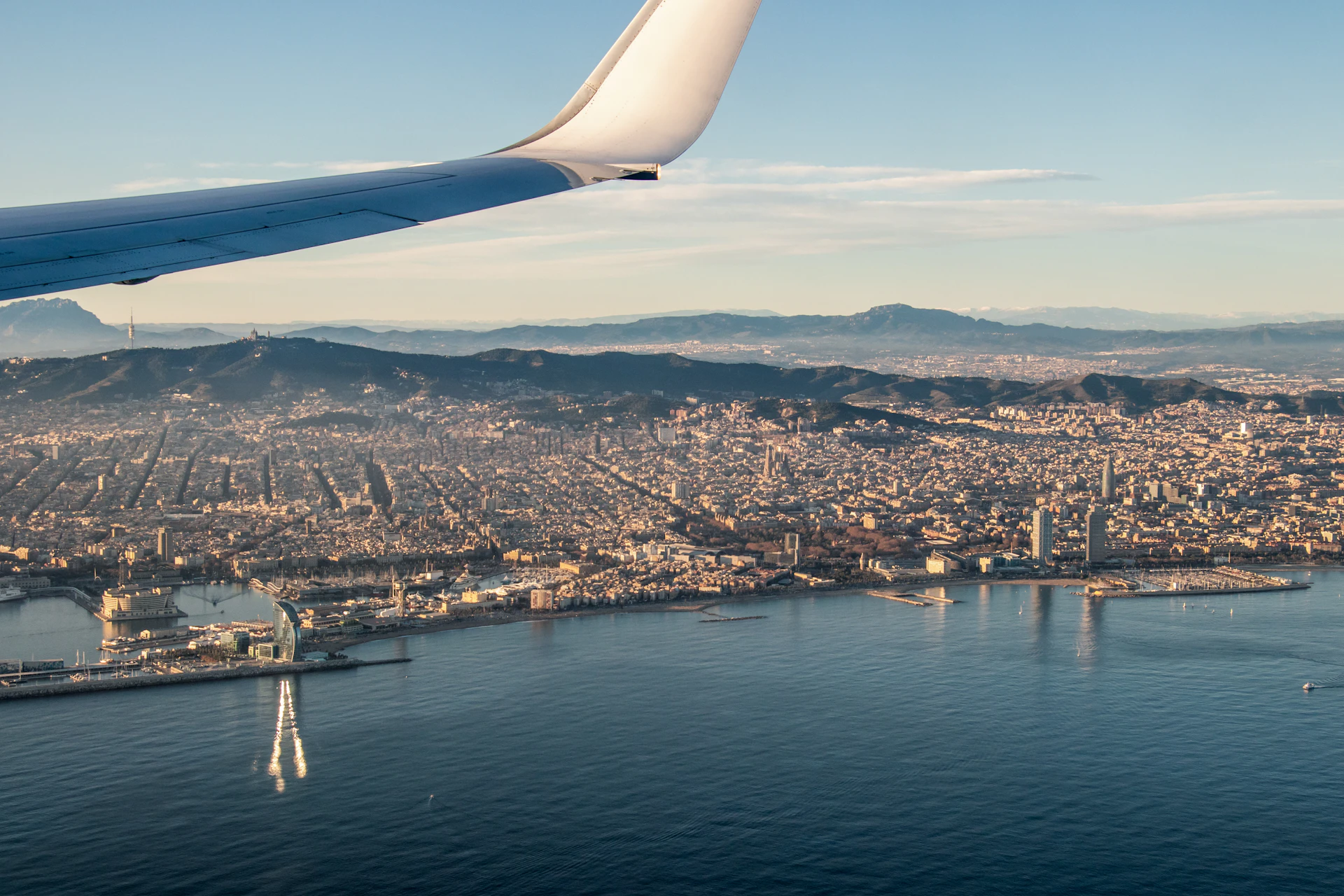 Aerial view of Barcelona and its coastline taken from an airplane wing.